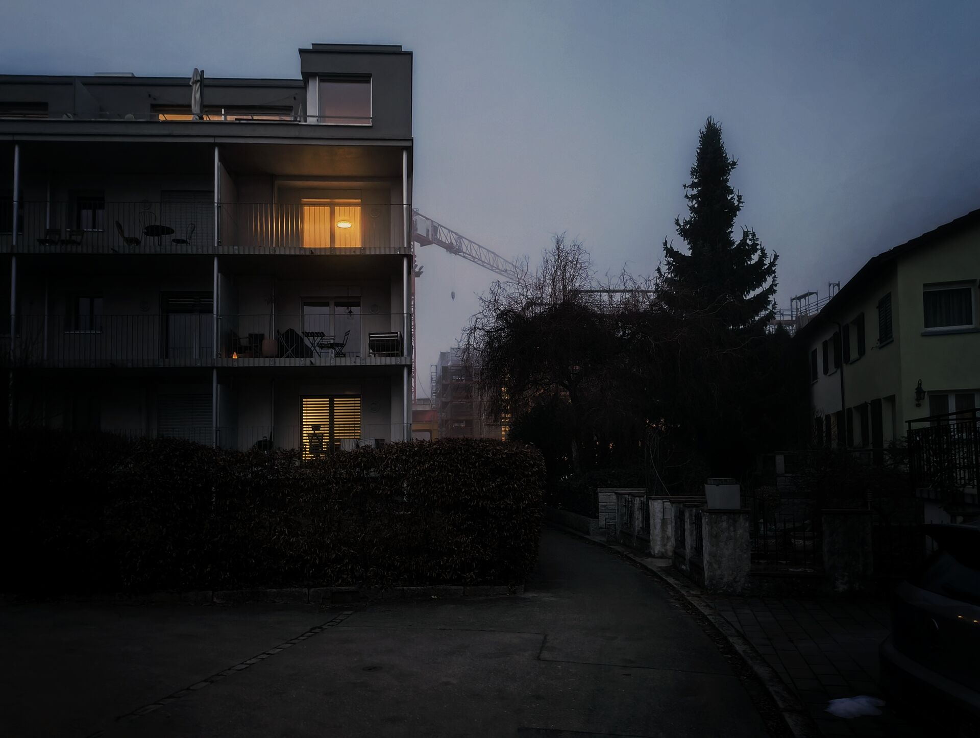 Apartment facade with balcony and illuminated room.