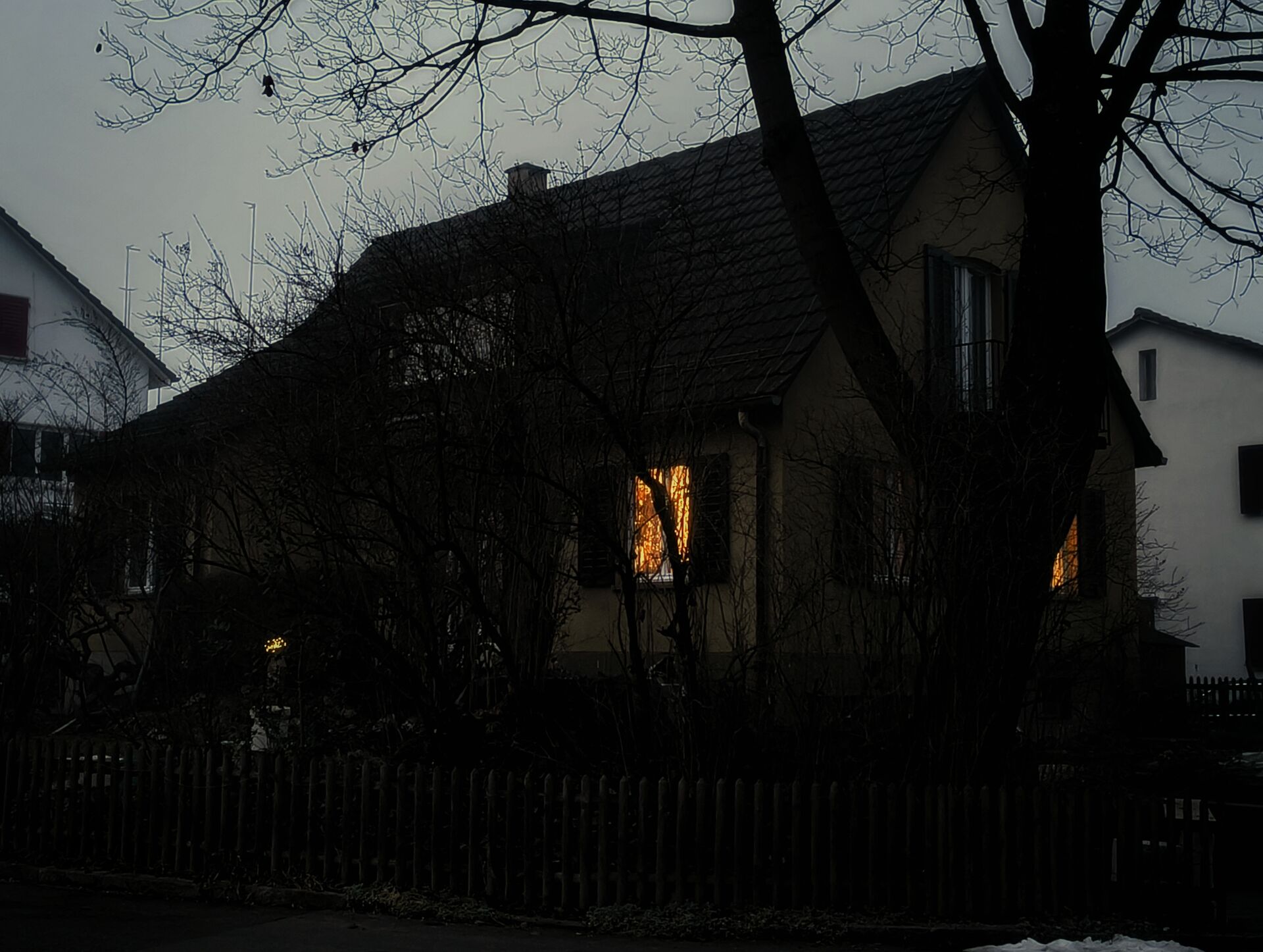 House facade with glowing windows at dusk.